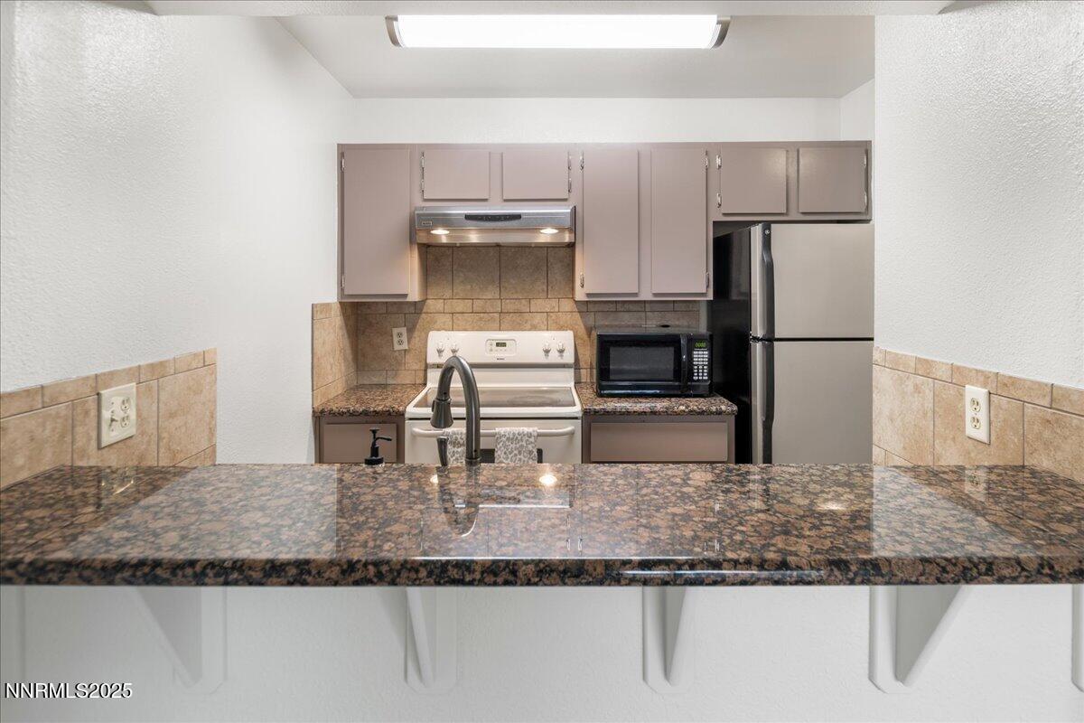 4418 Matich Drive Reno, NV 89502 - Photo 7 of 37 a kitchen with kitchen island a counter top space a sink stainless steel appliances and a counter top space