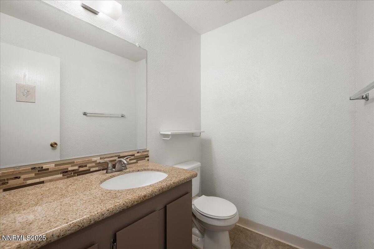4418 Matich Drive Reno, NV 89502 - Photo 10 of 37 a bathroom with a granite countertop sink and a toilet