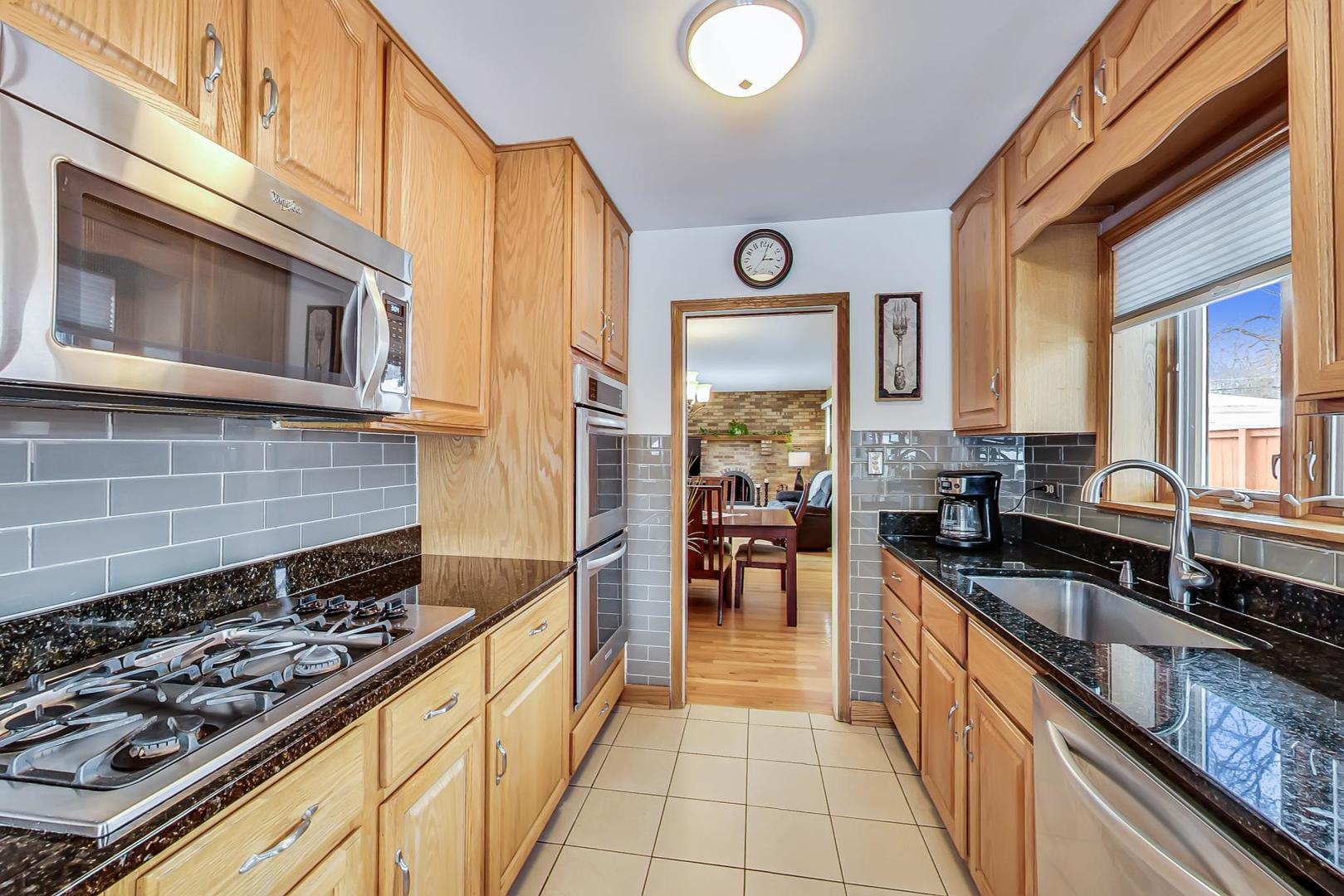715 Lamon Avenue Wilmette, IL 60091 - Photo 13 of 54 a kitchen with stainless steel appliances a stove sink and cabinets