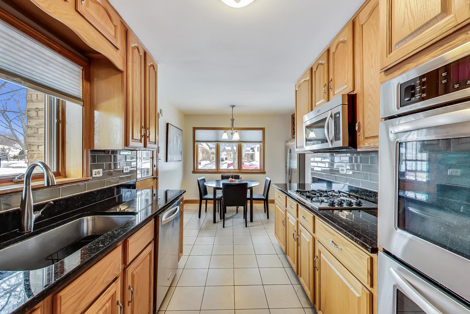 715 Lamon Avenue Wilmette, IL 60091 - Photo 14 of 54 a large kitchen with stainless steel appliances granite countertop a stove top oven a sink a dining table and chairs