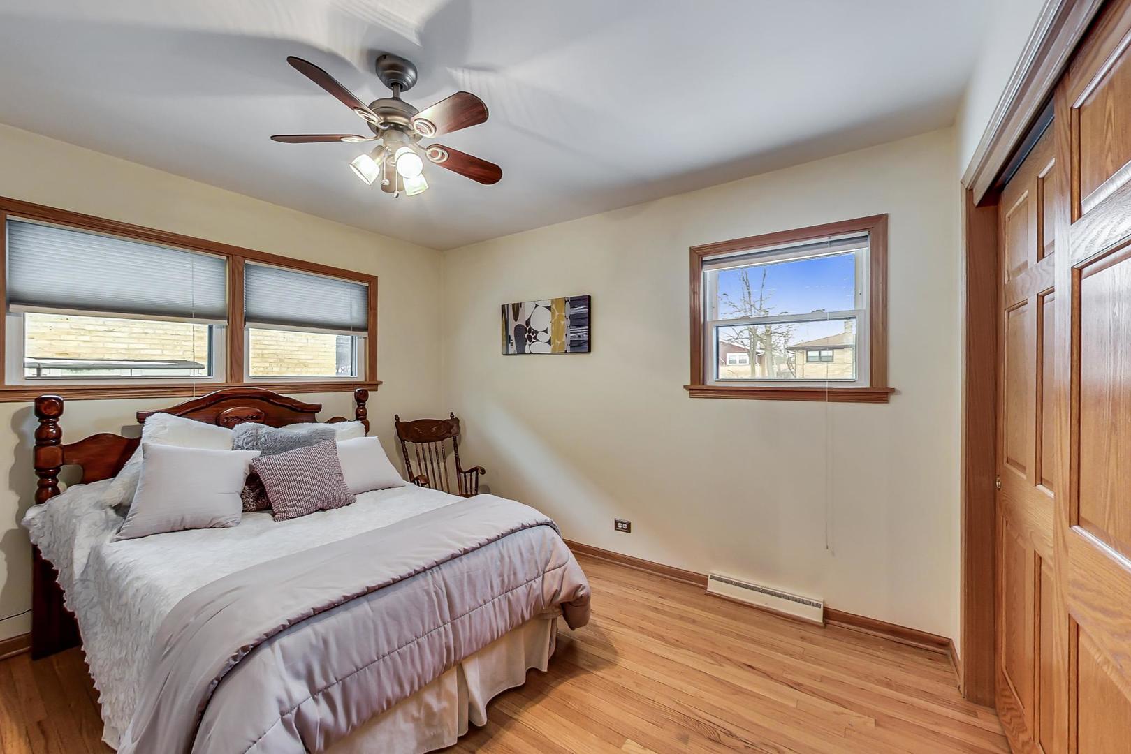715 Lamon Avenue Wilmette, IL 60091 - Photo 26 of 54 a bedroom with a large bed and a chandelier