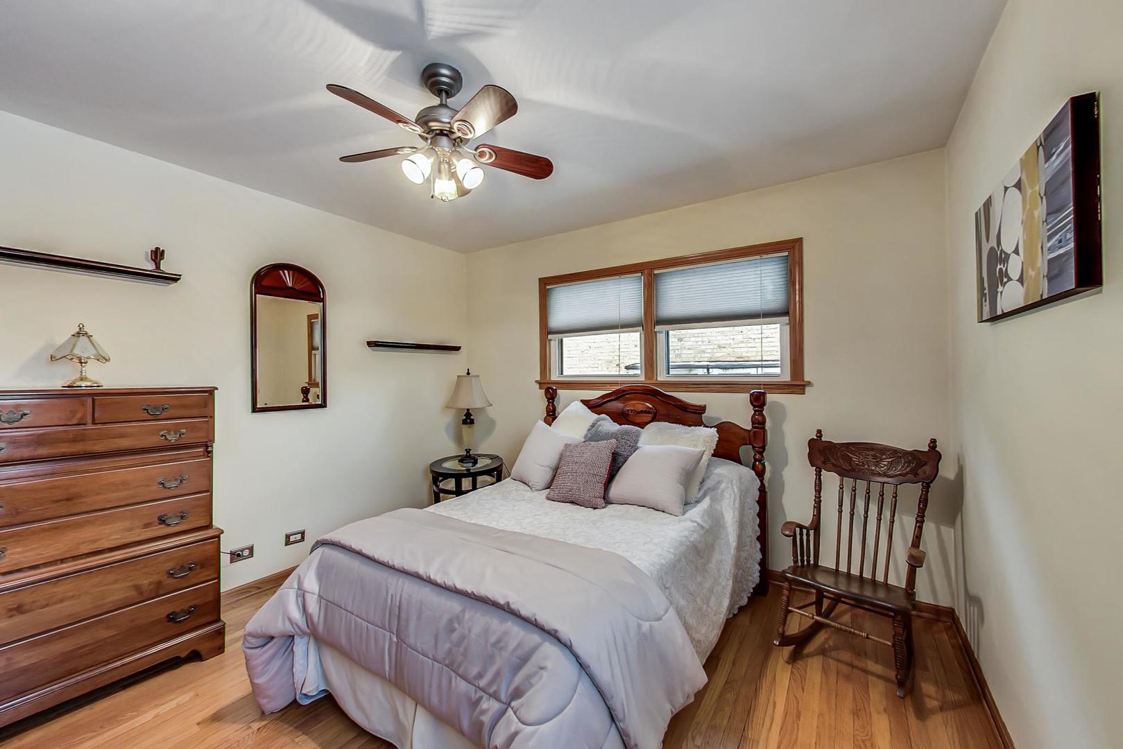 715 Lamon Avenue Wilmette, IL 60091 - Photo 27 of 54 a bedroom with a bed and a chandelier