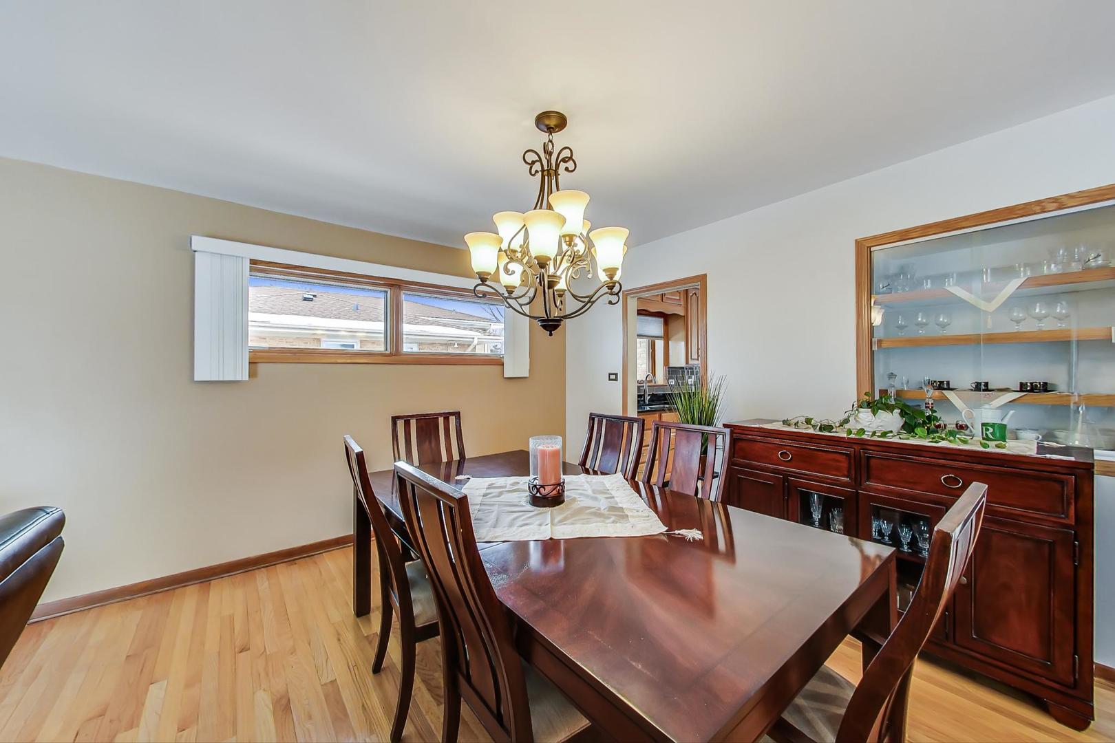 715 Lamon Avenue Wilmette, IL 60091 - Photo 9 of 54 a dining room with wooden floor a chandelier a wooden table and chairs