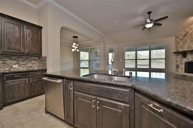 a kitchen with granite countertop a sink stainless steel appliances and window