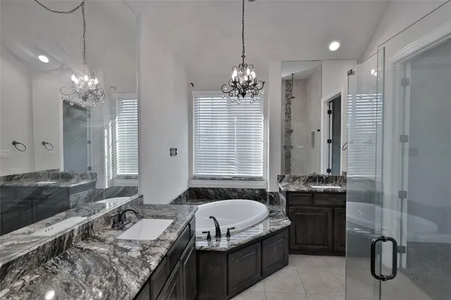 a spacious bathroom with a granite countertop sink a large mirror and a shower