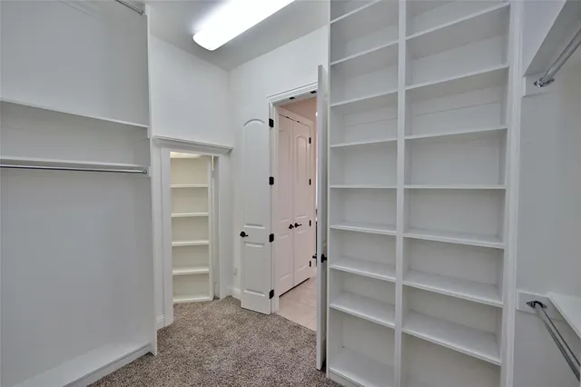 a view of walk in closet with empty racks