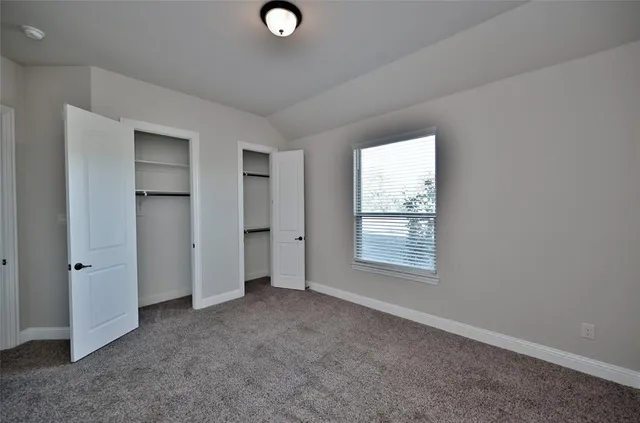 an empty room with windows and closet