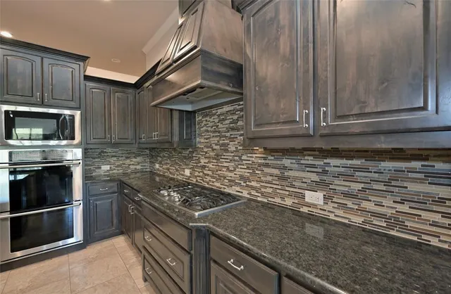 a kitchen with granite countertop a stove and cabinets