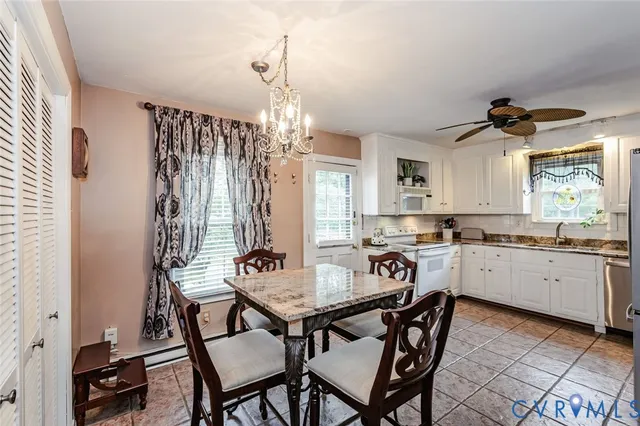 a kitchen with granite countertop white cabinets and window