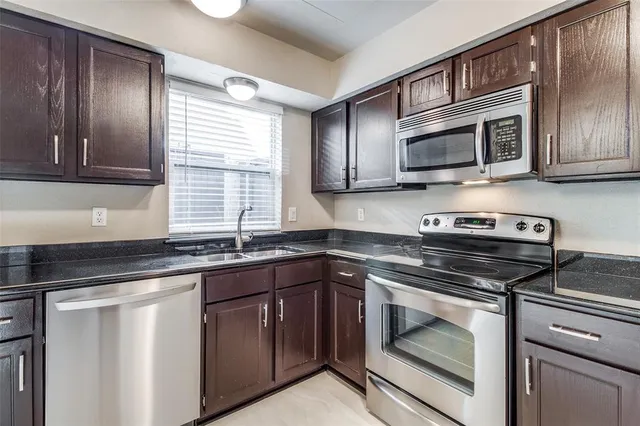 a kitchen with stainless steel appliances granite countertop a stove microwave and sink