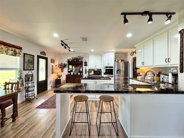 a large kitchen with stainless steel appliances lots of counter space and a sink