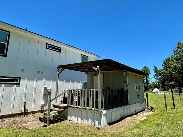 a view of a house with backyard and trees