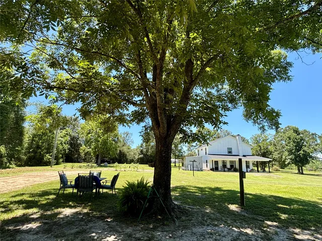 a view of a house with backyard and a tree