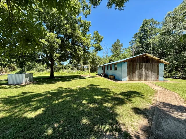 a backyard of a house with a yard and large trees