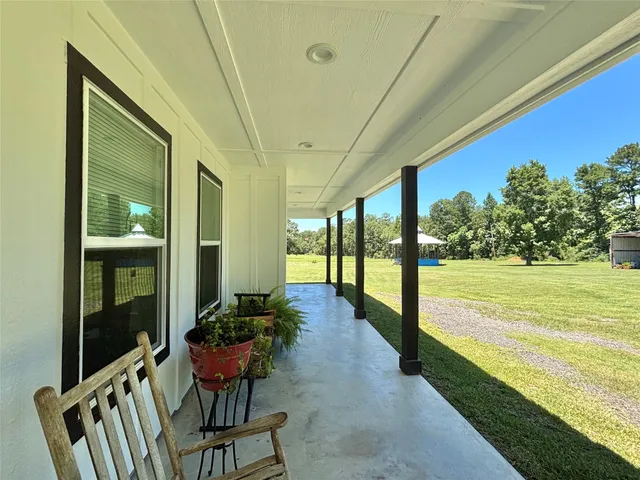 a view of a chairs and table in patio with wooden floor