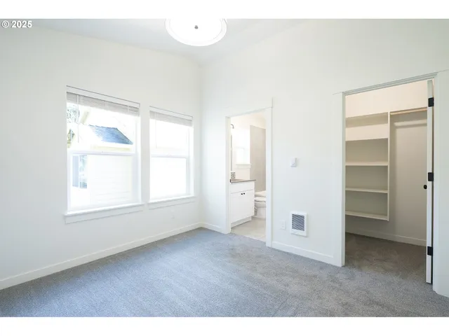 an empty room with windows and closet