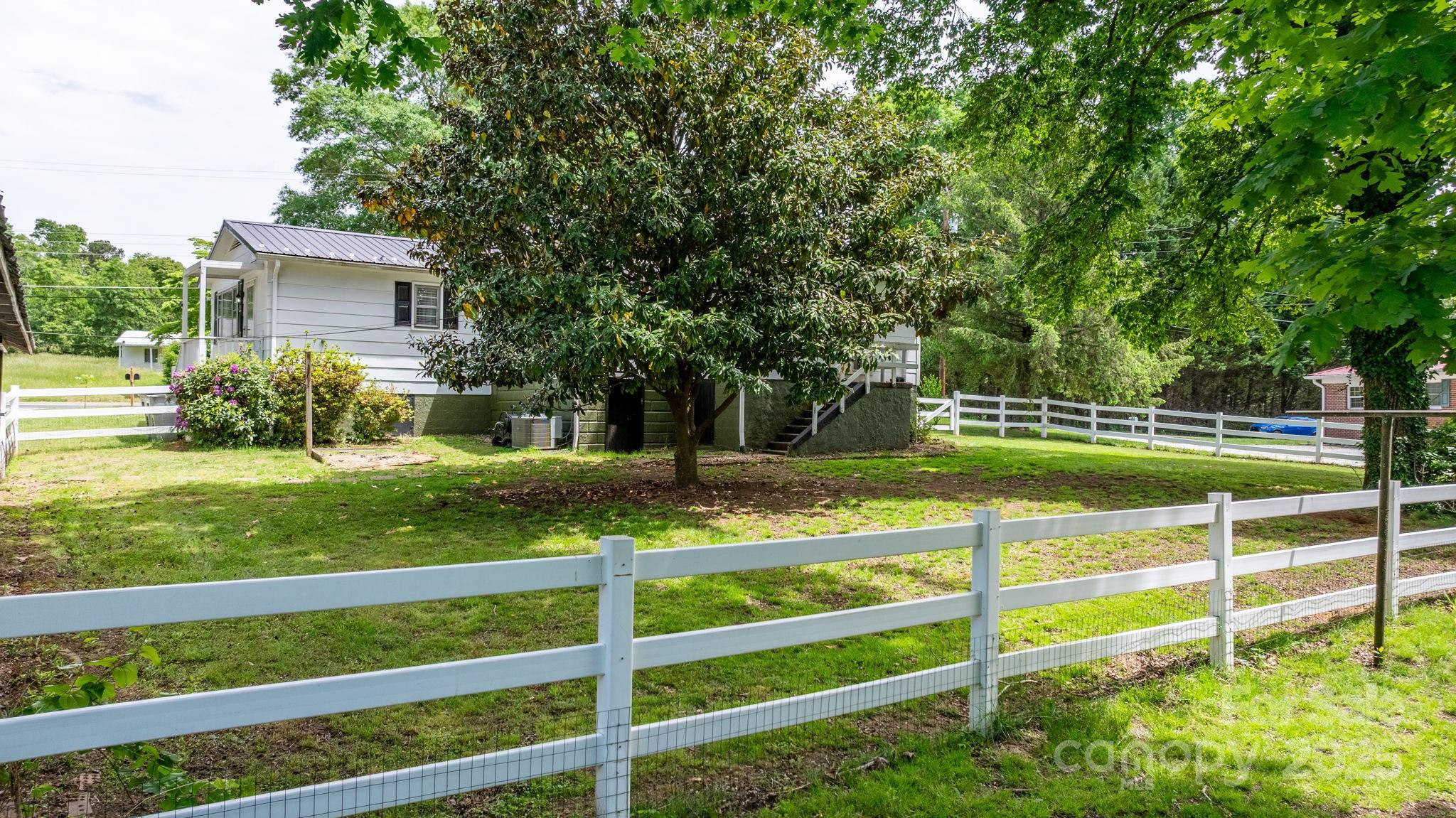 1826 Walt Arney Road Lenoir, NC 28645 - Photo 13 of 40 a view of a house with a big yard and large trees