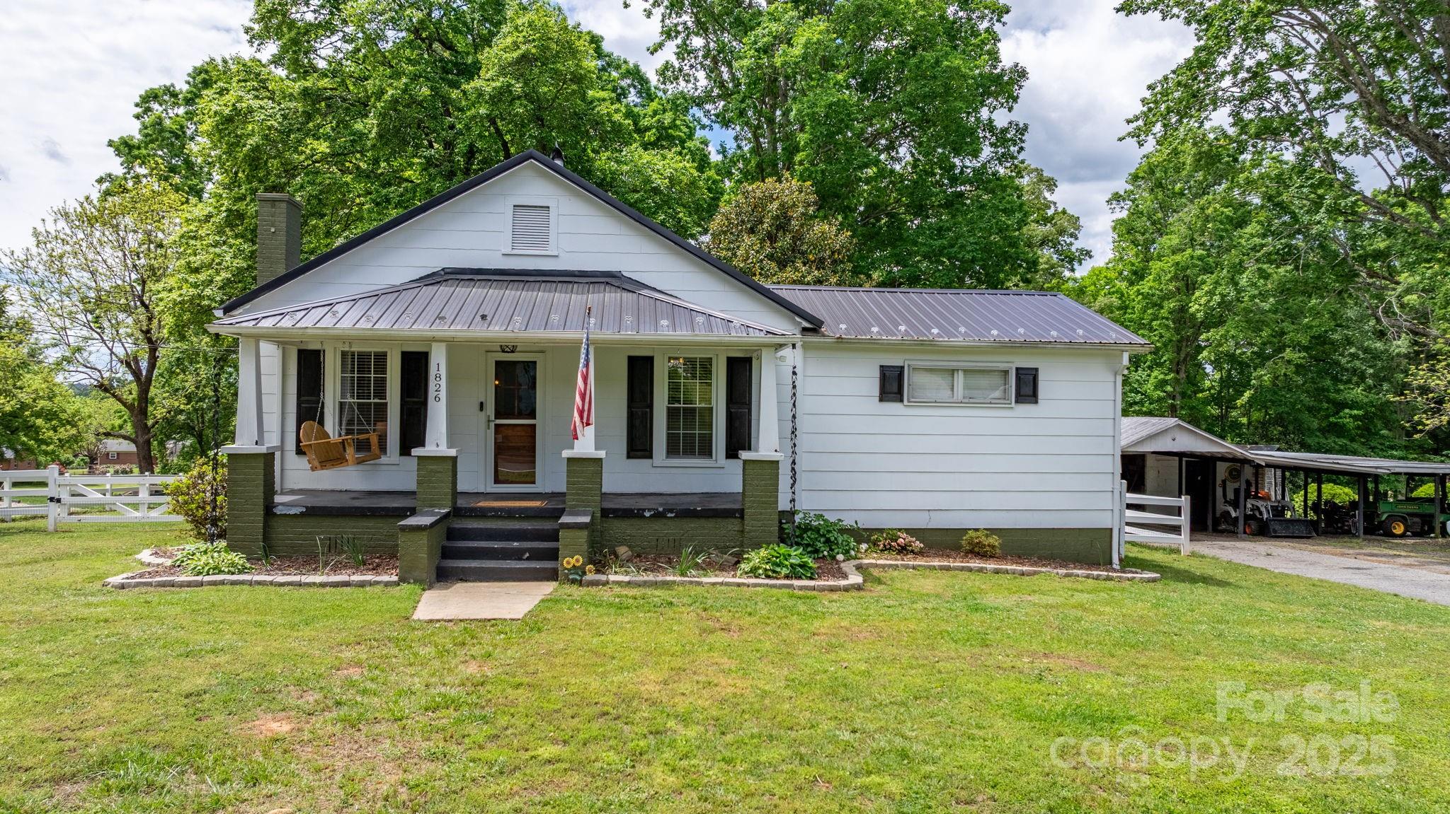 1826 Walt Arney Road Lenoir, NC 28645 - Photo 2 of 40 a front view of a house with a garden and porch