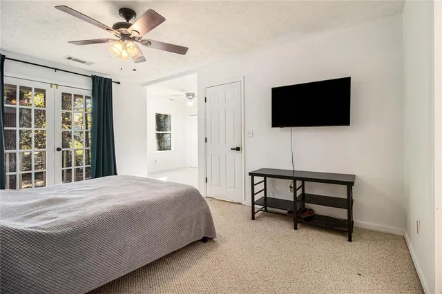 a bedroom with a bed a flat screen tv and a window