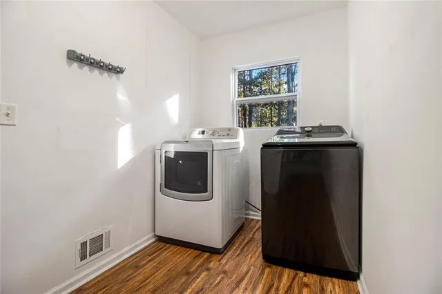 a utility room with wooden floor washer and dryer