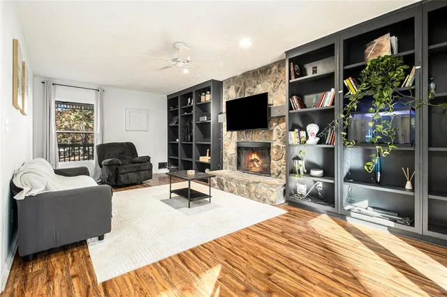 a living room with furniture a flat screen tv and a fireplace