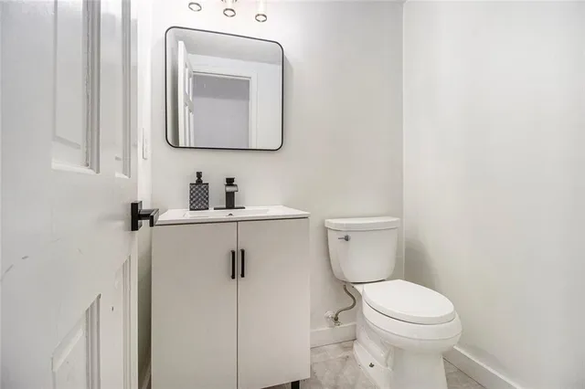 a bathroom with a toilet sink and mirror