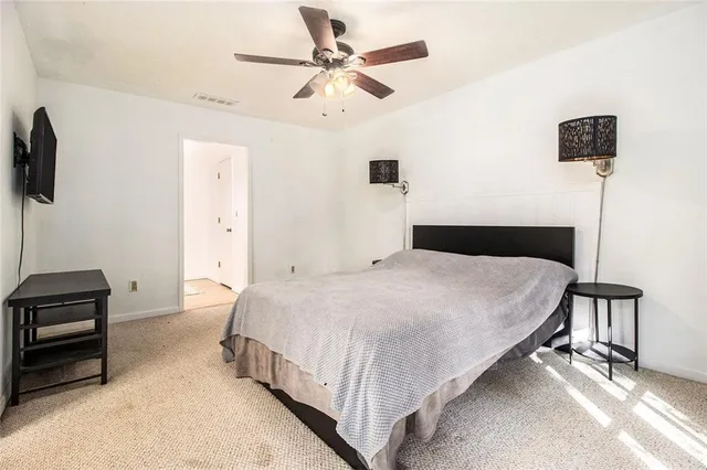 a bedroom with a bed and a ceiling fan