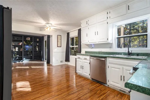 a kitchen with granite countertop a stove cabinets and wooden floor
