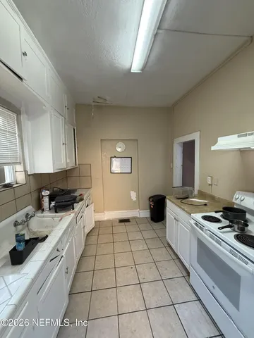 a kitchen with a stove a sink and a counter top space