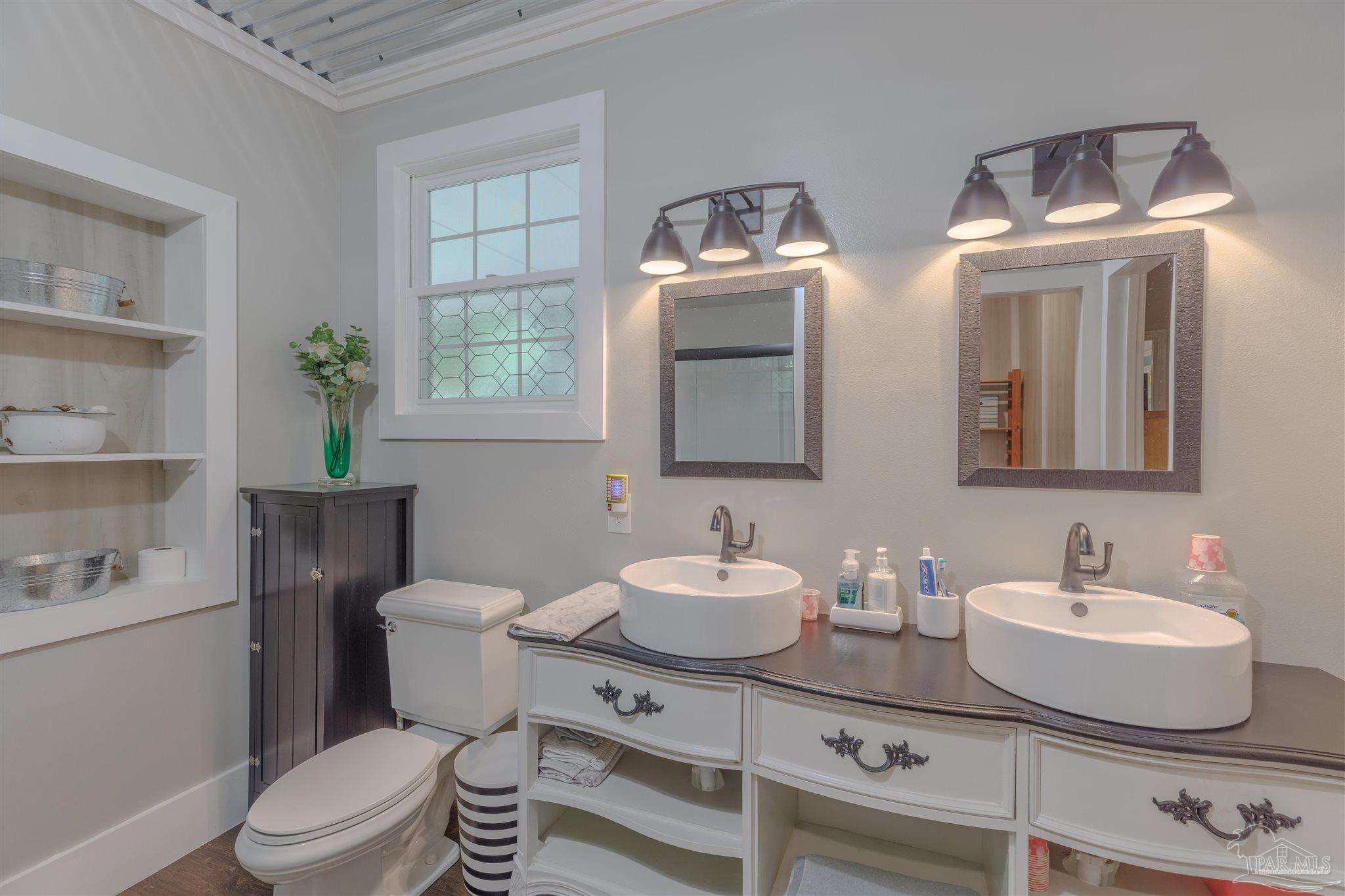 5049 Guernsey Road Pace, FL 32571 - Photo 39 of 61 a bathroom with a toilet a sink and mirror
