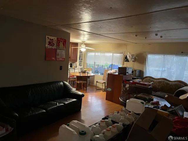 a living room with furniture and a view of kitchen