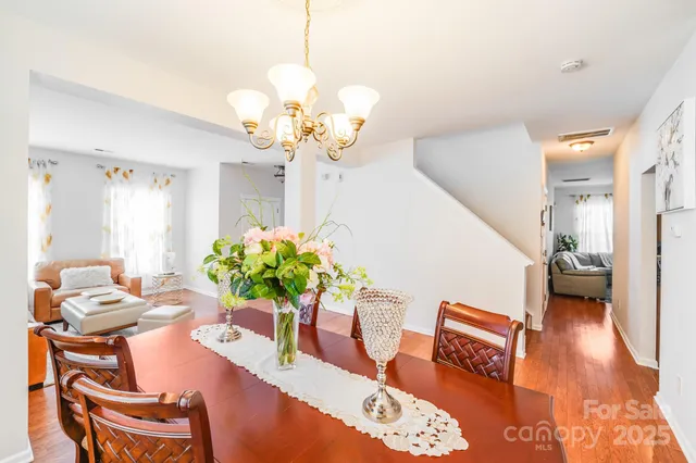 a living room with furniture a chandelier and a dining table