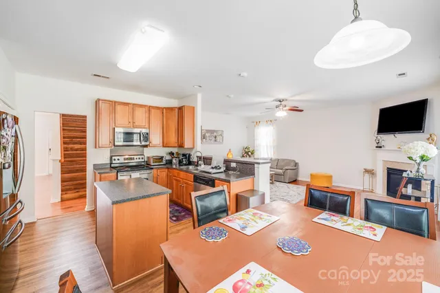 a large kitchen with a table chairs and flat screen tv