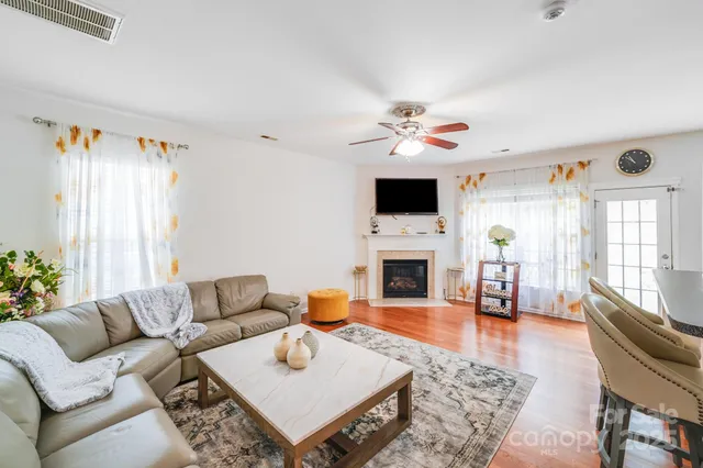 a living room with furniture a fireplace and a flat screen tv