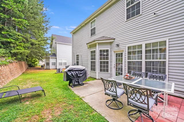 a view of a chair and table in backyard of the house