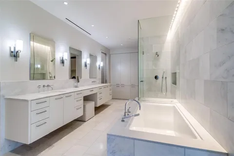 a bedroom with a bed a large window and walk in closet with a large window