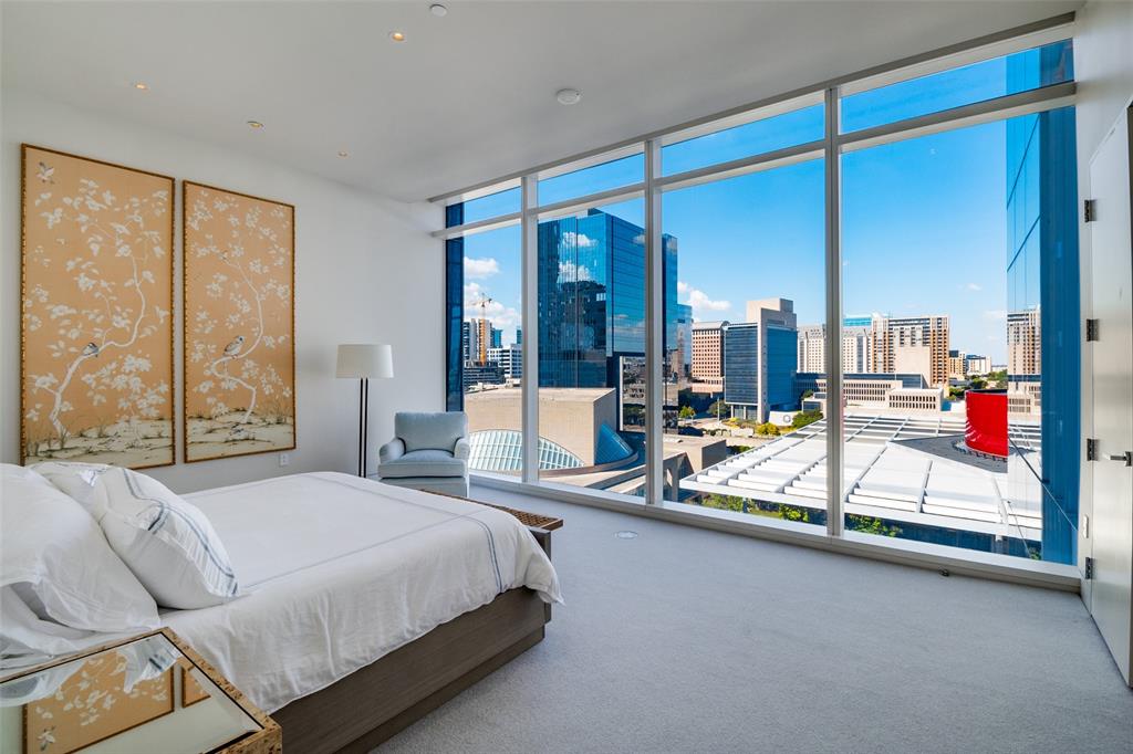 1747 Leonard Street, Unit 802 Dallas, TX 75201 - Photo 14 of 26 a bedroom with a bed a large window and walk in closet with a large window