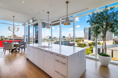 a large kitchen with kitchen island a large counter top a sink a stove and a refrigerator