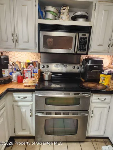 a stove top oven sitting inside of a kitchen