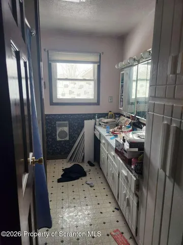 a kitchen with stainless steel appliances a stove a sink a refrigerator and windows