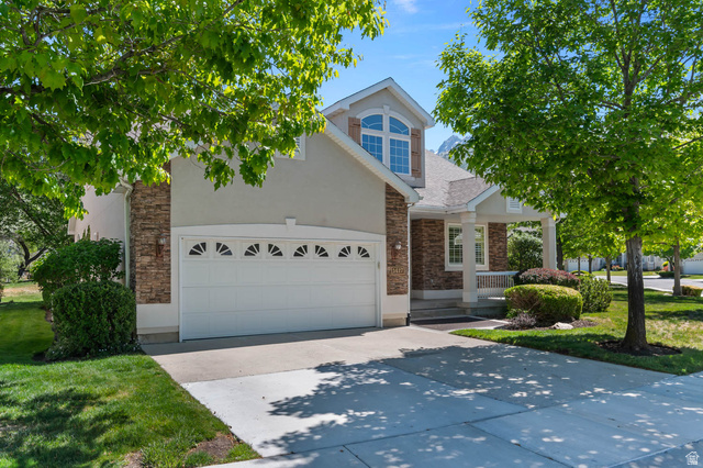 1417 Blacksmith Lane Draper, UT 84020 - Photo 2 of 57 Two-story residence featuring a stone and stucco exterior, an attached two-car garage with decorative windows, and a covered front porch with white columns