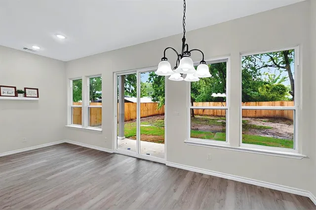 a view of a room with wooden floor fireplace and windows