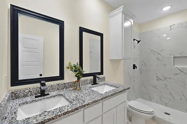 a bathroom with double sink and a mirror