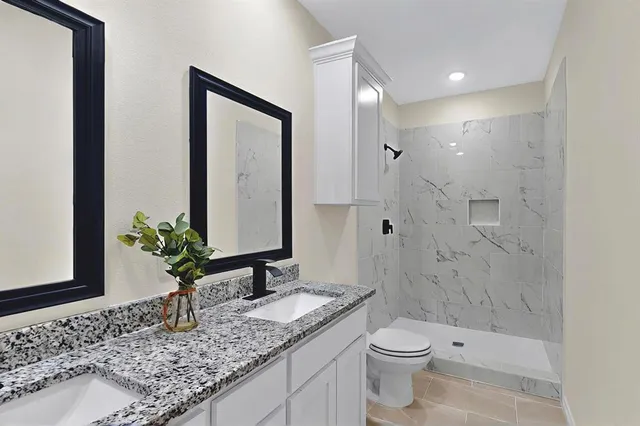 a bathroom with a granite countertop sink toilet and shower