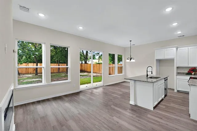 a kitchen with stainless steel appliances granite countertop a stove a sink and a large window