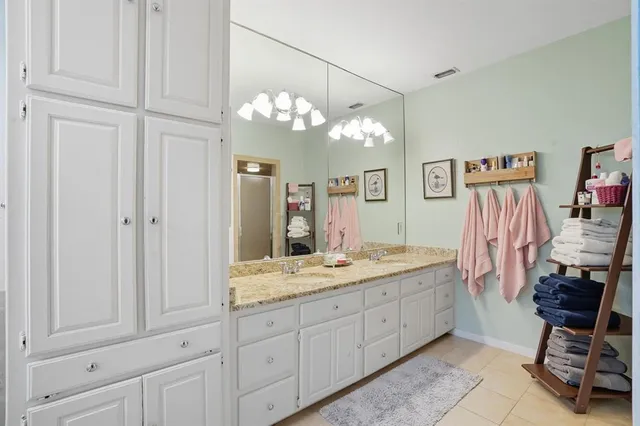 a spacious bathroom with a granite countertop sink a toilet and a mirror