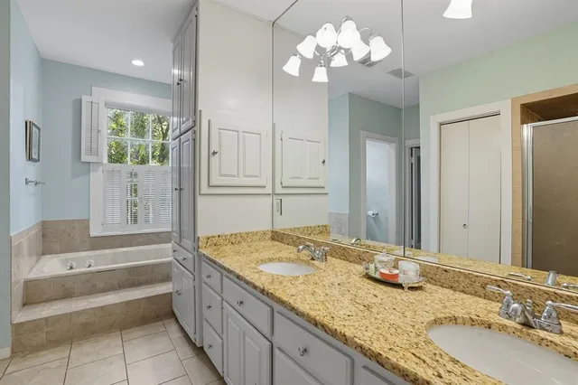a bathroom with a granite countertop double vanity sink and a mirror
