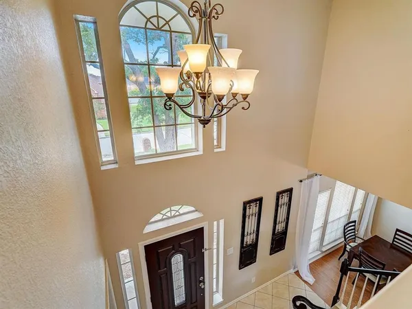 a view of a room with wooden floor and chandelier