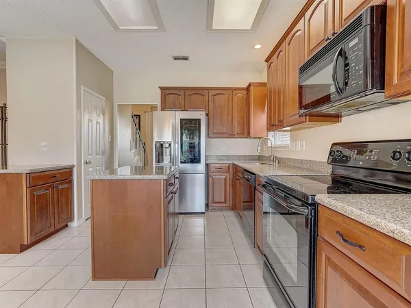 a kitchen with kitchen island a counter top space appliances and cabinets