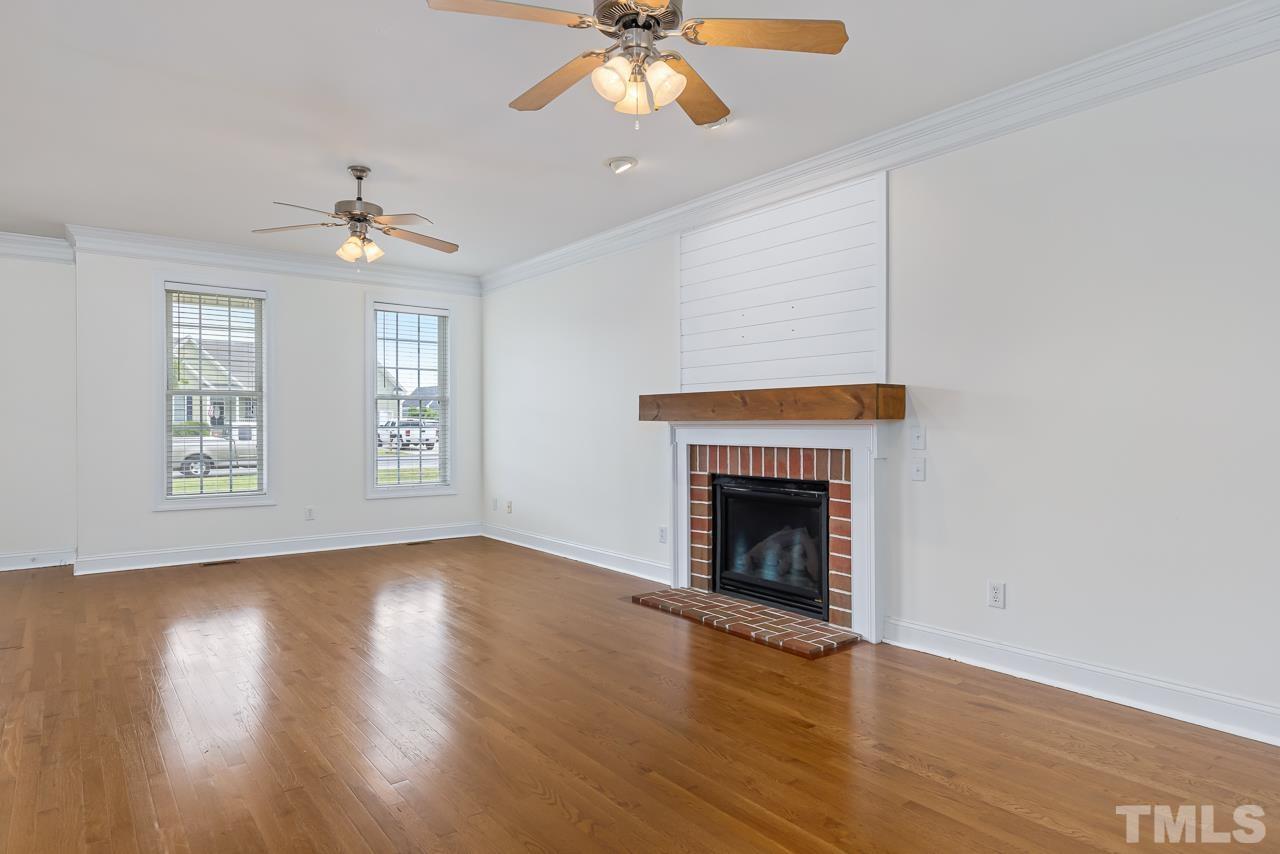 65 Bess Lane Angier, NC 27501 - Photo 15 of 38 an empty room with windows fireplace and wooden floor